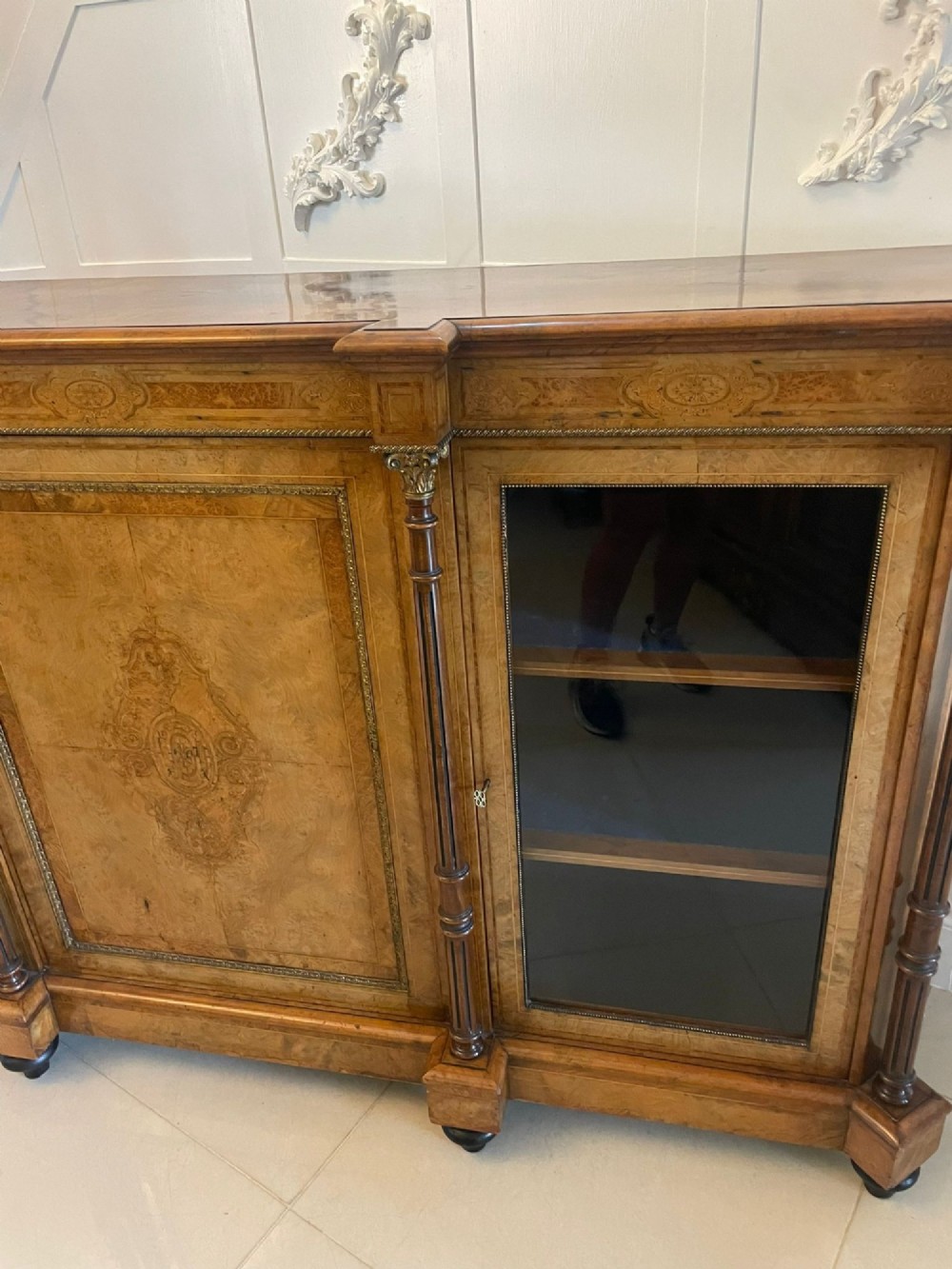 A Victorian burr walnut credenza featuring a central marquetry inlaid timber door flanked by two glazed side cabinets and turned column supports. View II