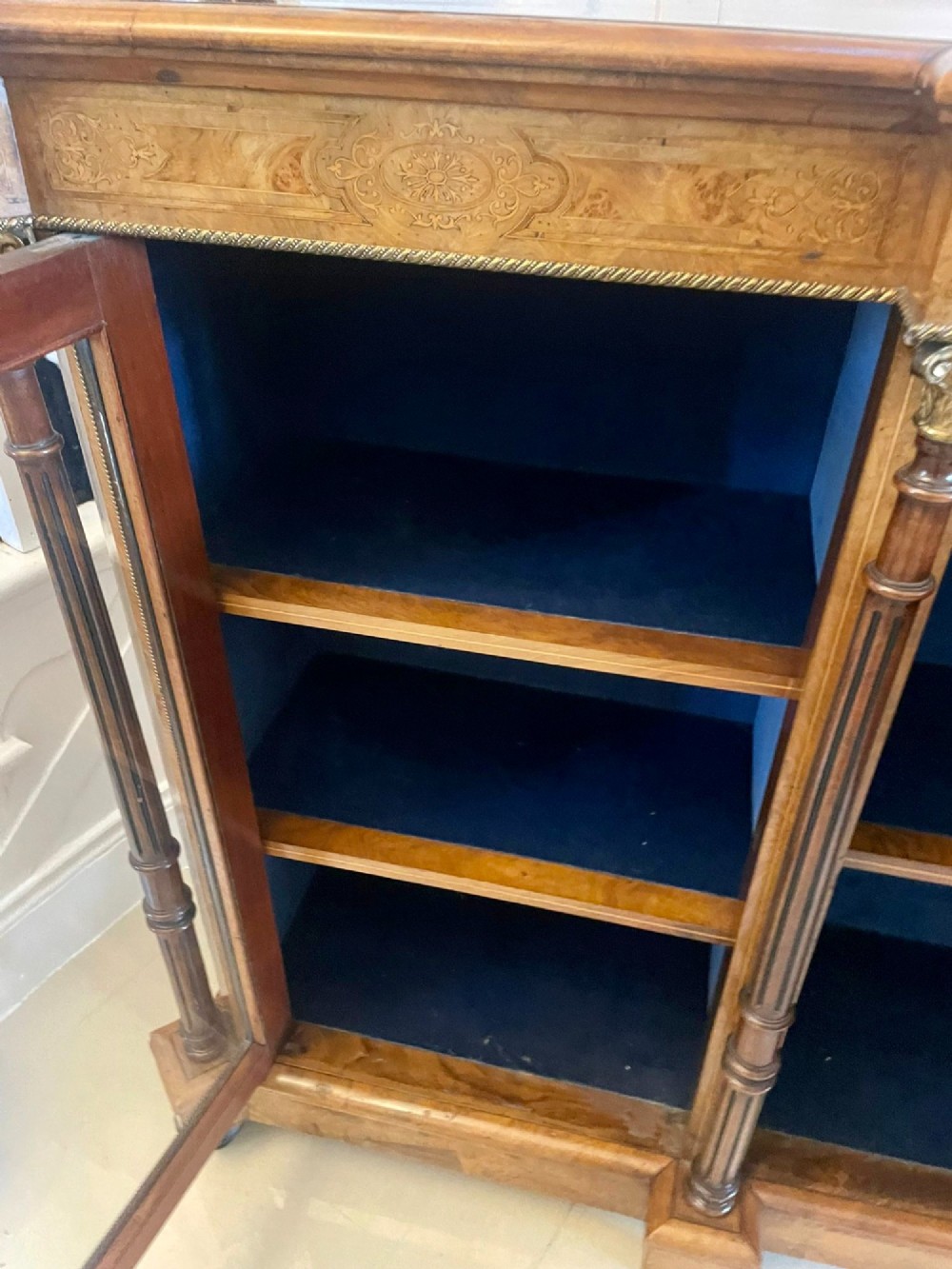 A Victorian burr walnut credenza featuring a central marquetry inlaid timber door flanked by two glazed side cabinets and turned column supports. View V