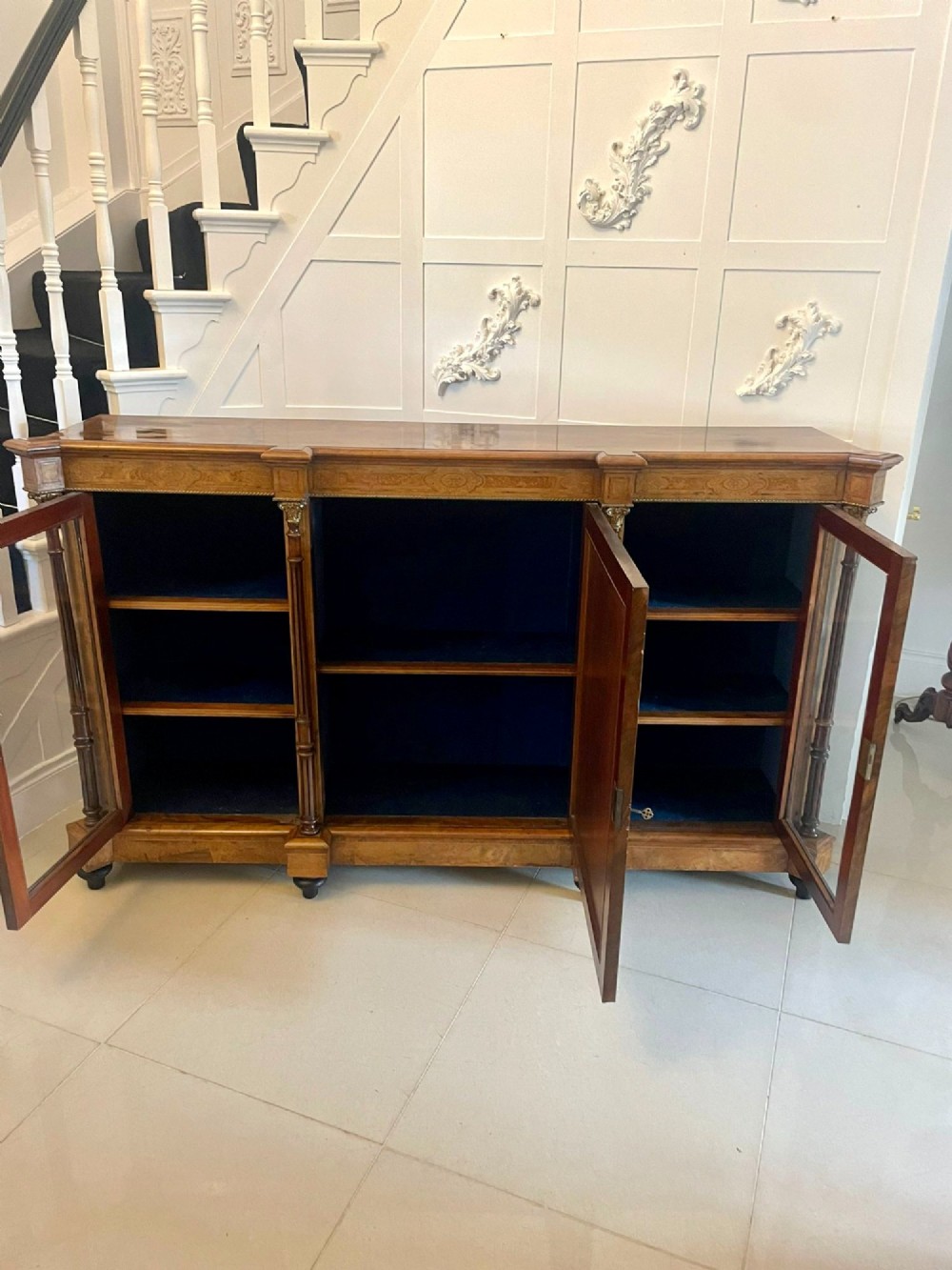 A Victorian burr walnut credenza featuring a central marquetry inlaid timber door flanked by two glazed side cabinets and turned column supports. View VII