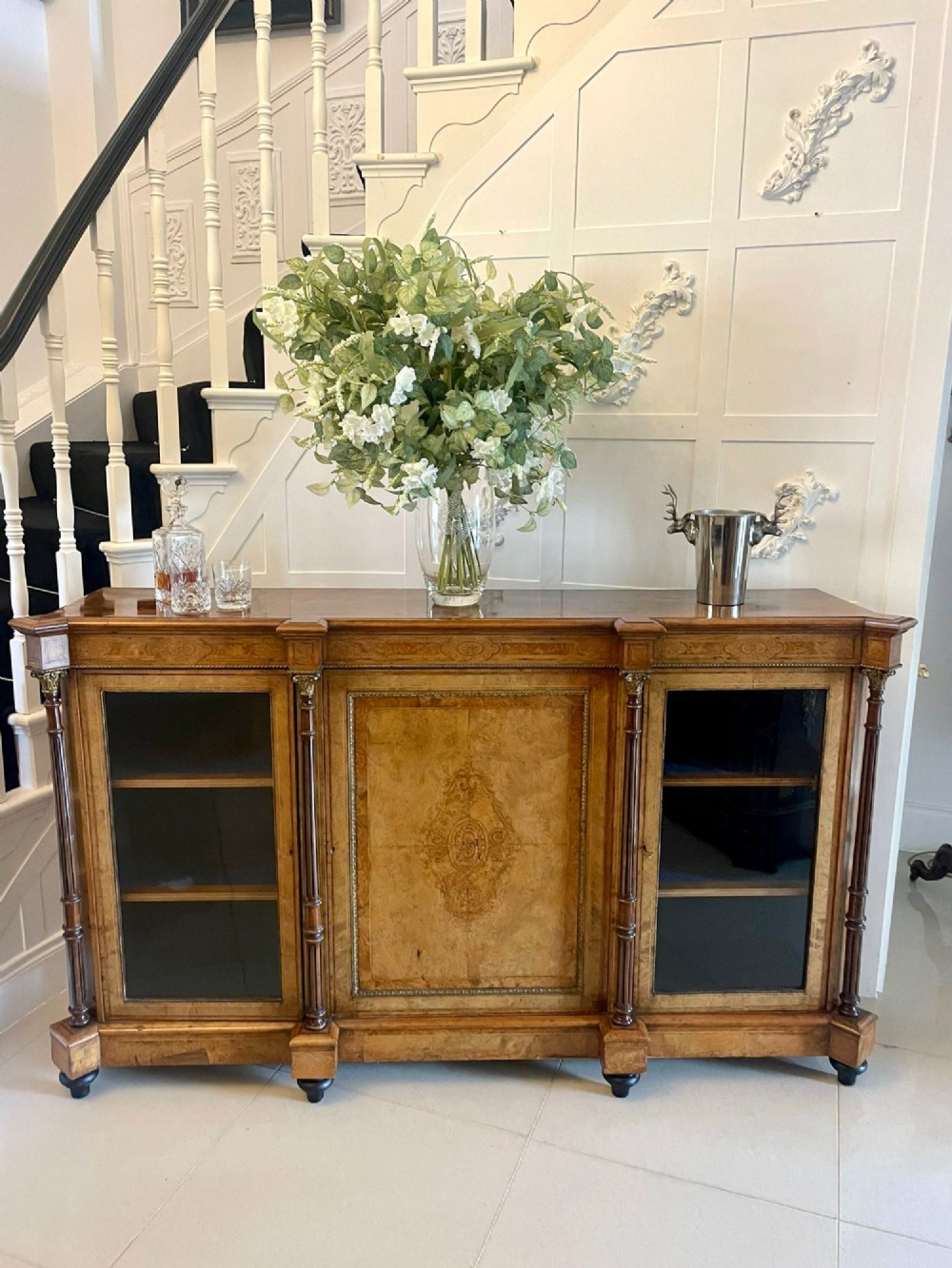 A Victorian burr walnut credenza featuring a central marquetry inlaid timber door flanked by two glazed side cabinets and turned column supports. View VIII