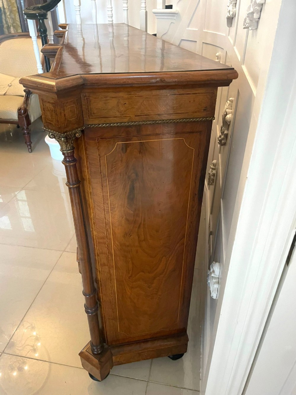 A Victorian burr walnut credenza featuring a central marquetry inlaid timber door flanked by two glazed side cabinets and turned column supports. View XI