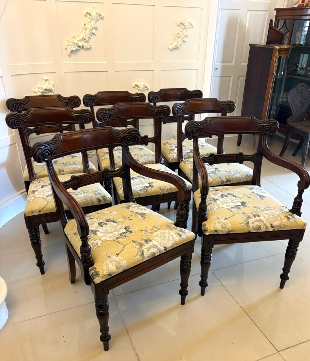 A set of eight Regency mahogany dining chairs comprising six side chairs and two carver armchairs with scroll-carved top rails and turned front legs. View III