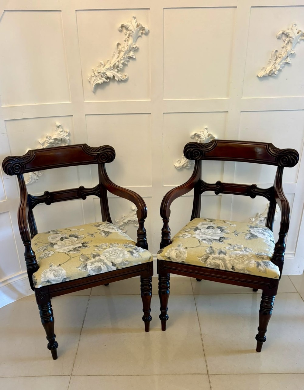 A set of eight Regency mahogany dining chairs comprising six side chairs and two carver armchairs with scroll-carved top rails and turned front legs. View VI