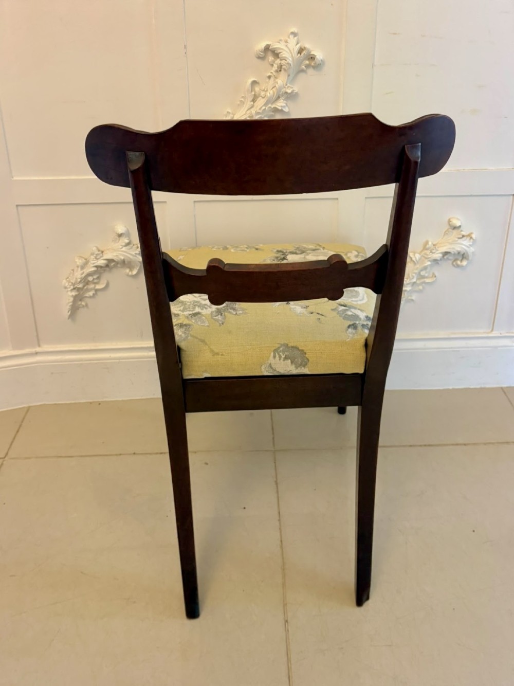 A set of eight Regency mahogany dining chairs comprising six side chairs and two carver armchairs with scroll-carved top rails and turned front legs. View VII