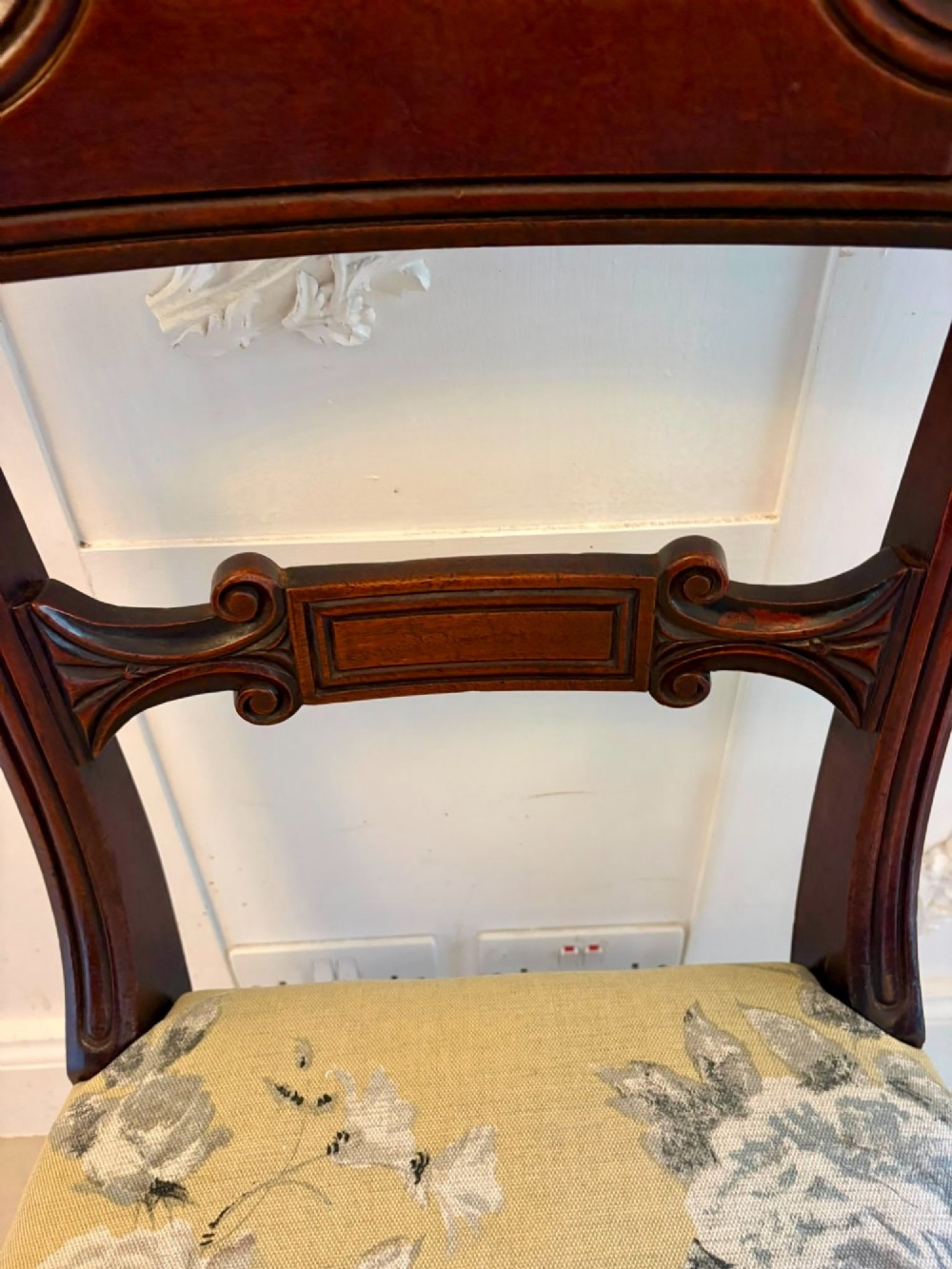 A set of eight Regency mahogany dining chairs comprising six side chairs and two carver armchairs with scroll-carved top rails and turned front legs. View IX