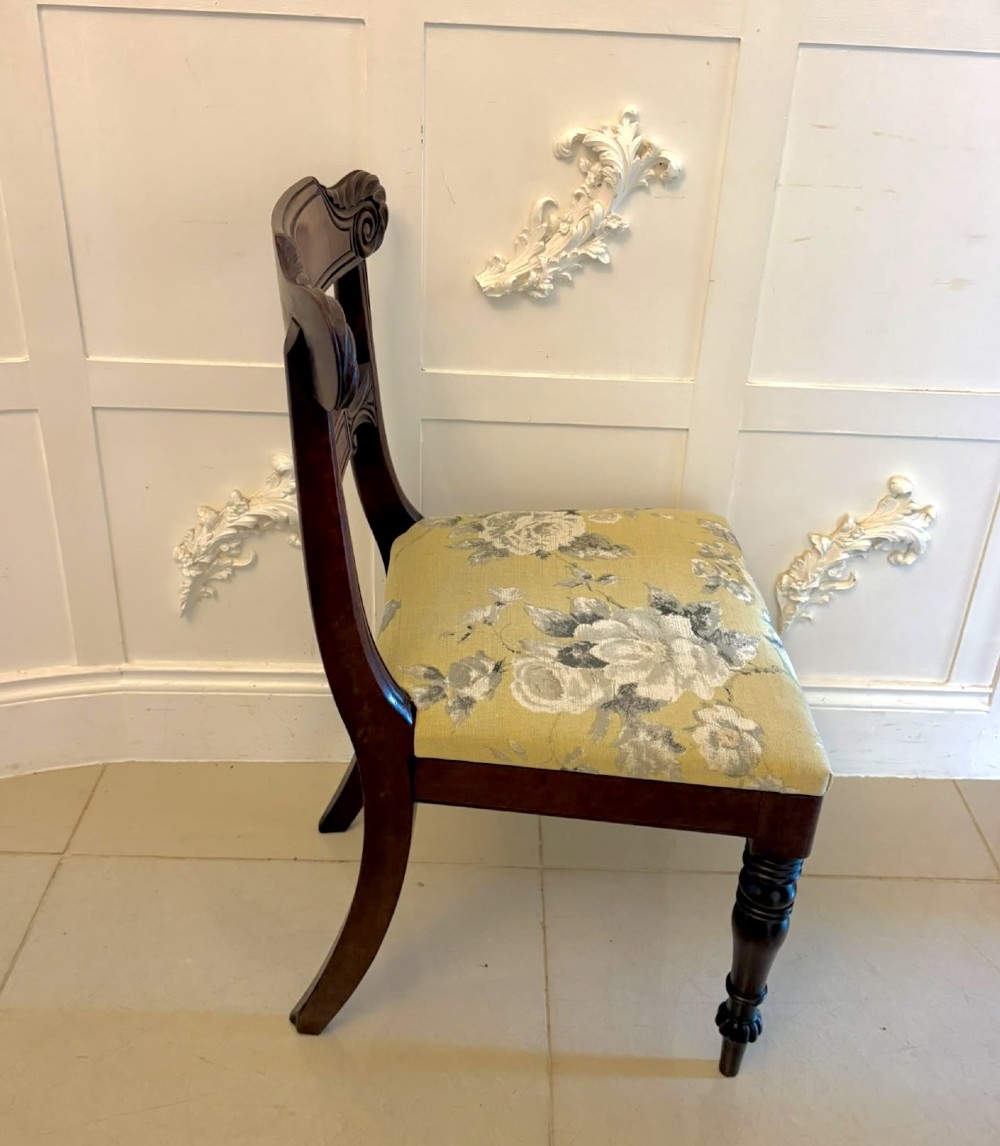 A set of eight Regency mahogany dining chairs comprising six side chairs and two carver armchairs with scroll-carved top rails and turned front legs. View XI
