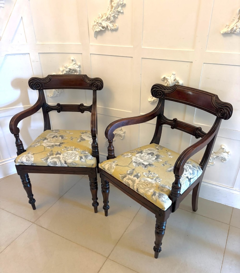 A set of eight Regency mahogany dining chairs comprising six side chairs and two carver armchairs with scroll-carved top rails and turned front legs. View XIII