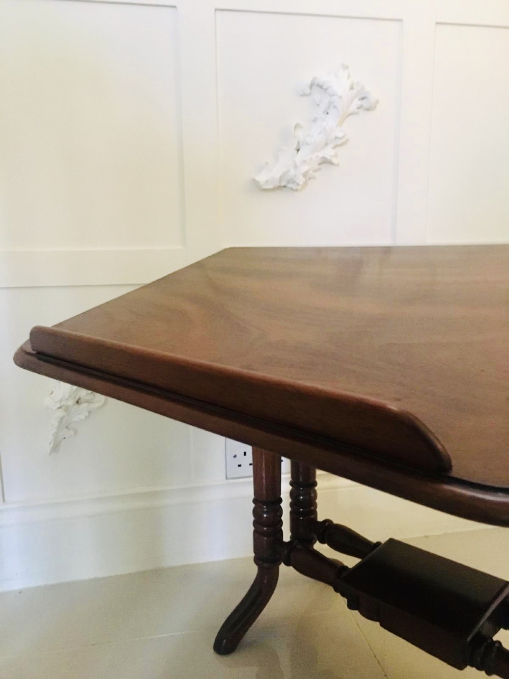 An antique mahogany Sutherland table featuring hinged drop leaves, turned legs with horizontal stretchers, and a central wooden base block. View VIII