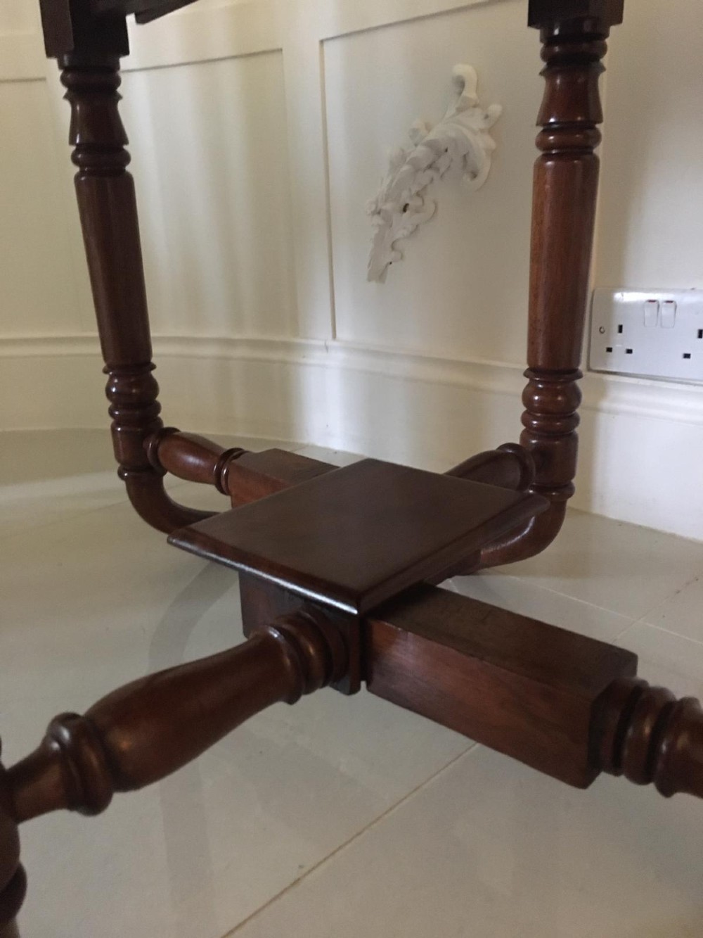 An antique mahogany Sutherland table featuring hinged drop leaves, turned legs with horizontal stretchers, and a central wooden base block. View X