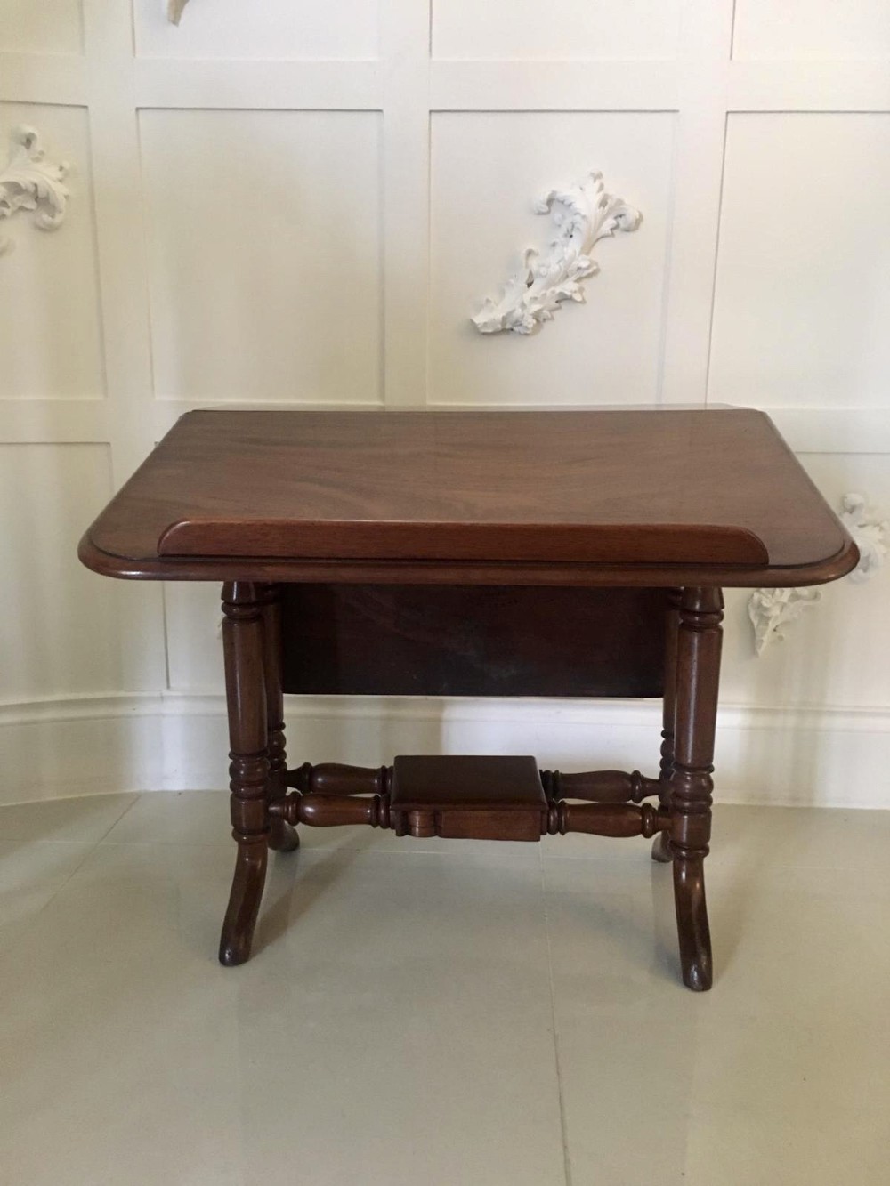 An antique mahogany Sutherland table featuring hinged drop leaves, turned legs with horizontal stretchers, and a central wooden base block. View XI