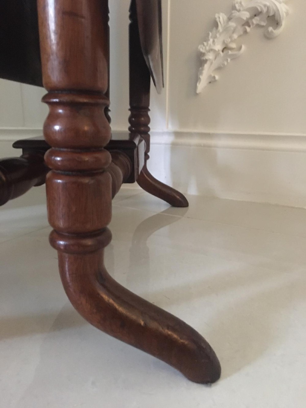An antique mahogany Sutherland table featuring hinged drop leaves, turned legs with horizontal stretchers, and a central wooden base block. View XII