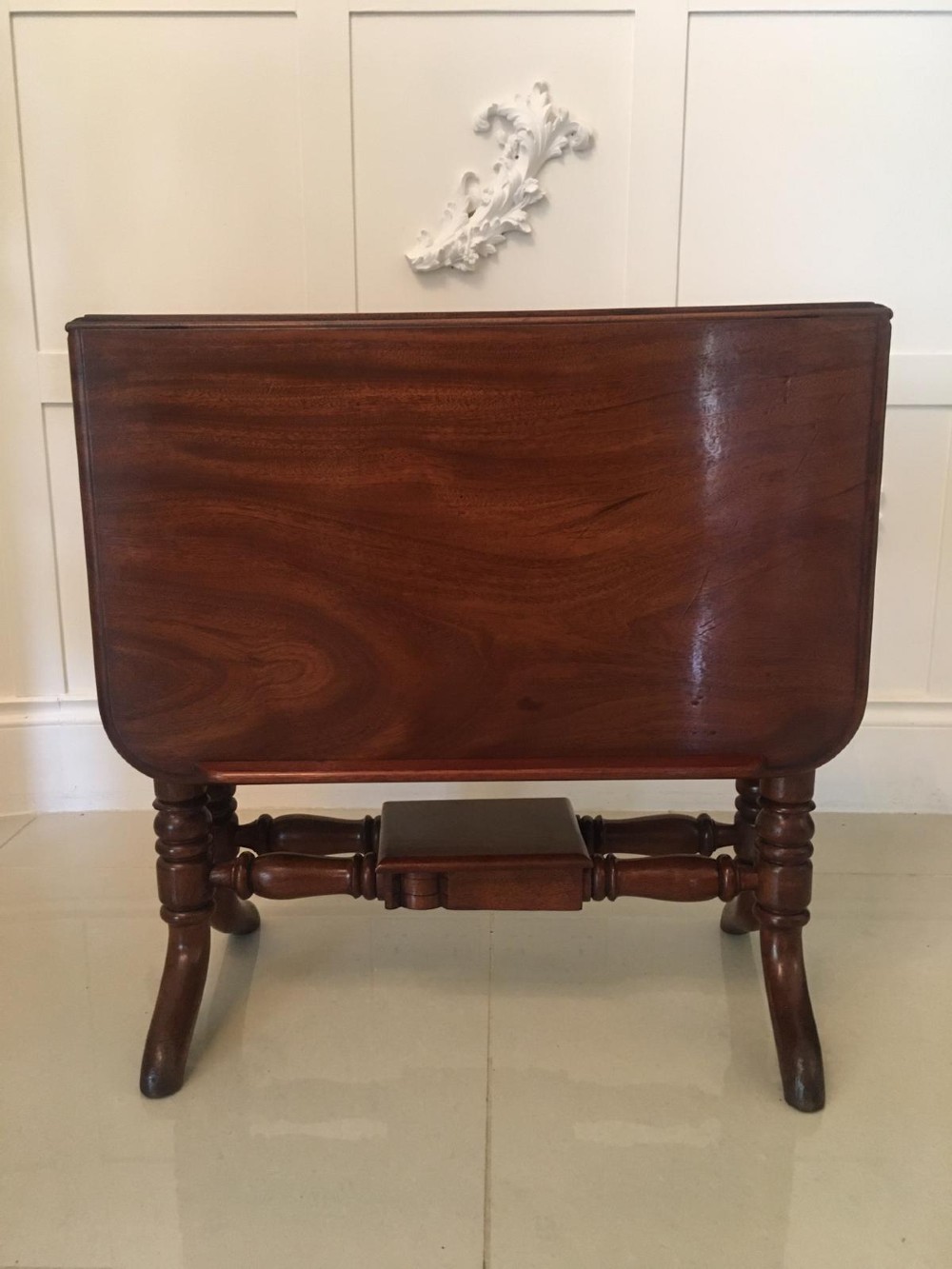 An antique mahogany Sutherland table featuring hinged drop leaves, turned legs with horizontal stretchers, and a central wooden base block. View XIII