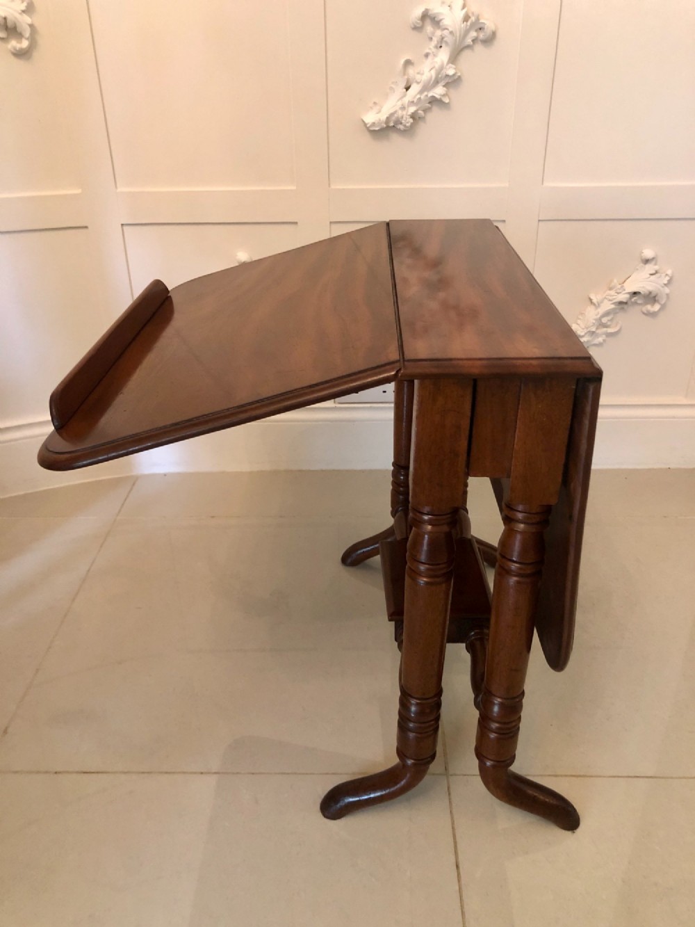 An antique mahogany Sutherland table featuring hinged drop leaves, turned legs with horizontal stretchers, and a central wooden base block. View XIV
