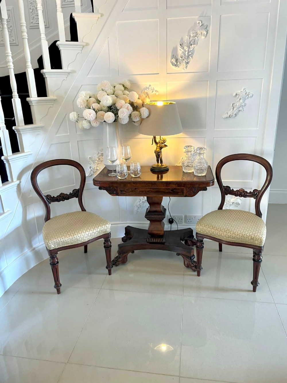 A William IV dark rosewood fold-over card table featuring a gadrooned top edge, scroll carvings, a central pedestal column, and a plinth base on carved claw feet. View IV