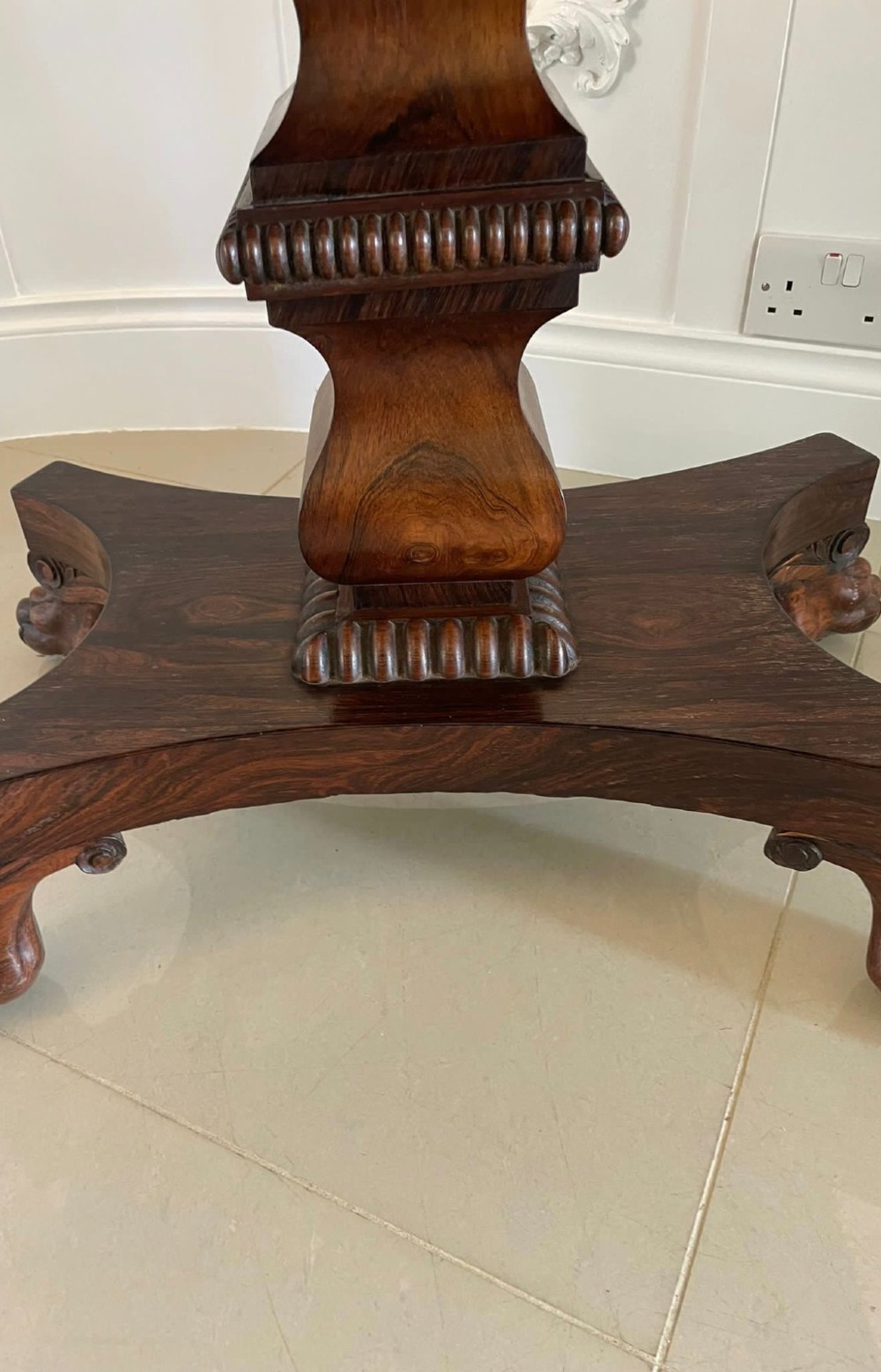 A William IV dark rosewood fold-over card table featuring a gadrooned top edge, scroll carvings, a central pedestal column, and a plinth base on carved claw feet. View X