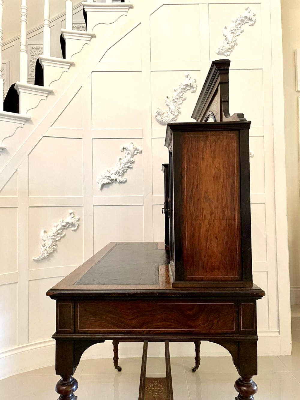 An antique Victorian dark rosewood writing desk featuring decorative floral marquetry inlays, turned legs, and an upper superstructure with twin glazed cabinets and an arched mirror. View V
