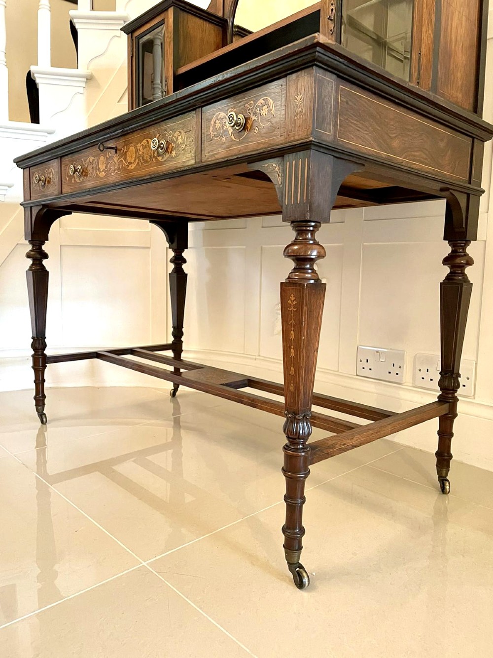 An antique Victorian dark rosewood writing desk featuring decorative floral marquetry inlays, turned legs, and an upper superstructure with twin glazed cabinets and an arched mirror. View VIII