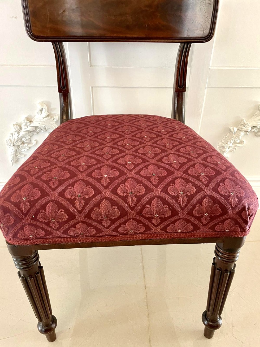 Set of six Regency mahogany library chairs with carved top rails, red patterned upholstered seats, and fluted turned front legs. View IV