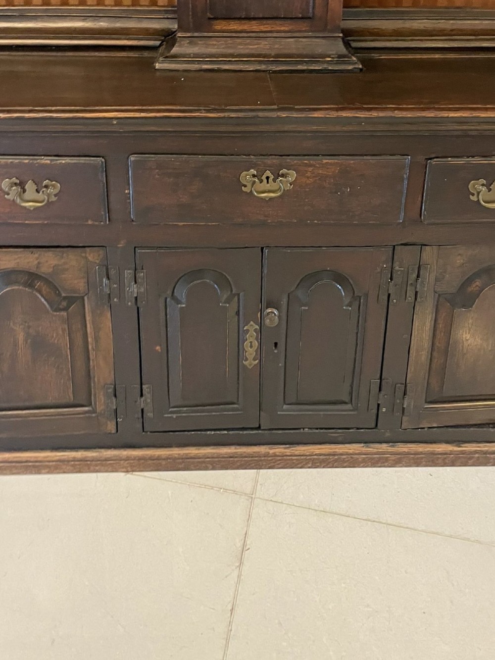 An eighteenth-century dark oak George III dresser featuring an upper shelf rack with an integrated central longcase clock over a base with three drawers and six arched panel cupboard doors. View VIII