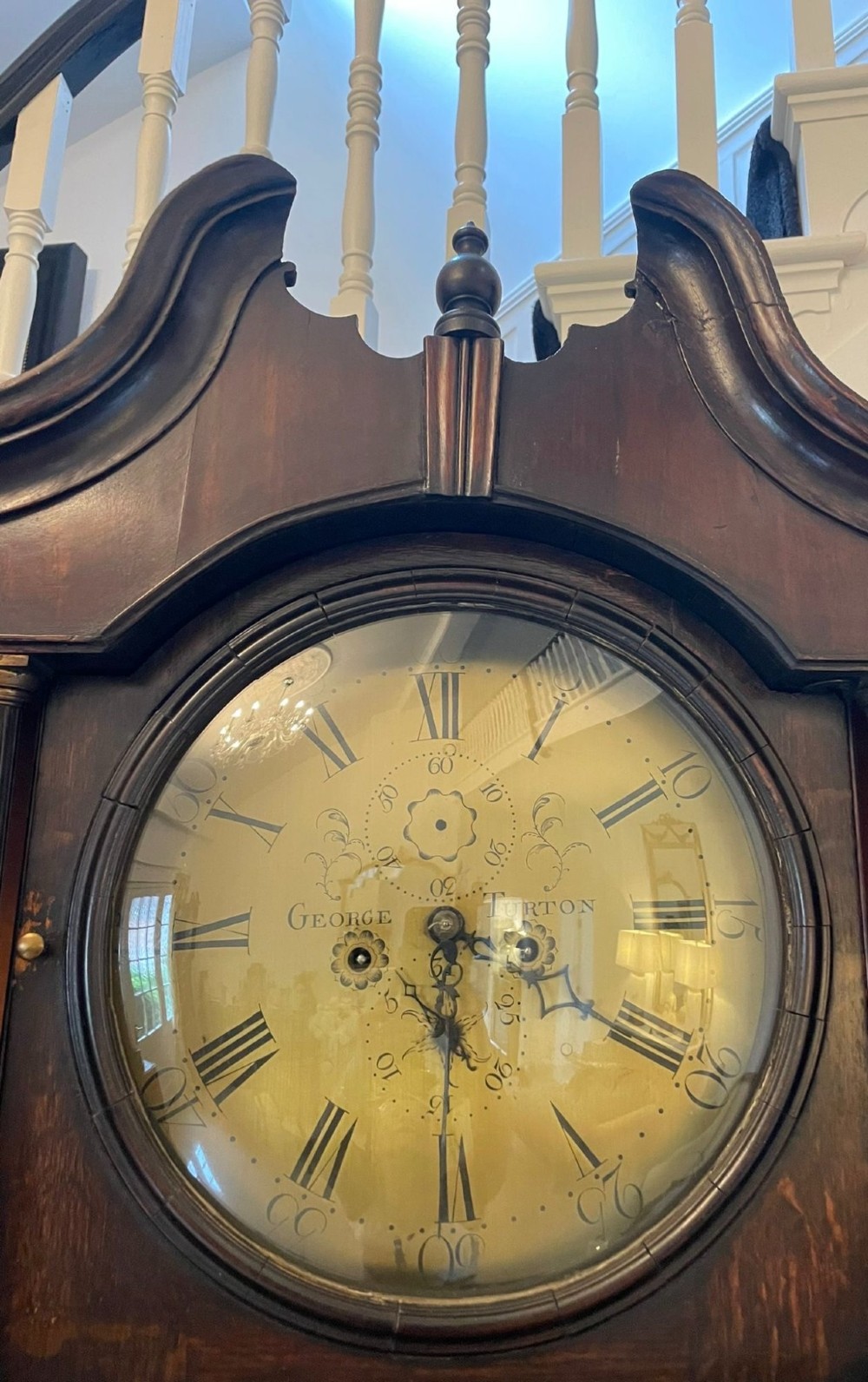An eighteenth-century dark oak George III dresser featuring an upper shelf rack with an integrated central longcase clock over a base with three drawers and six arched panel cupboard doors. View X