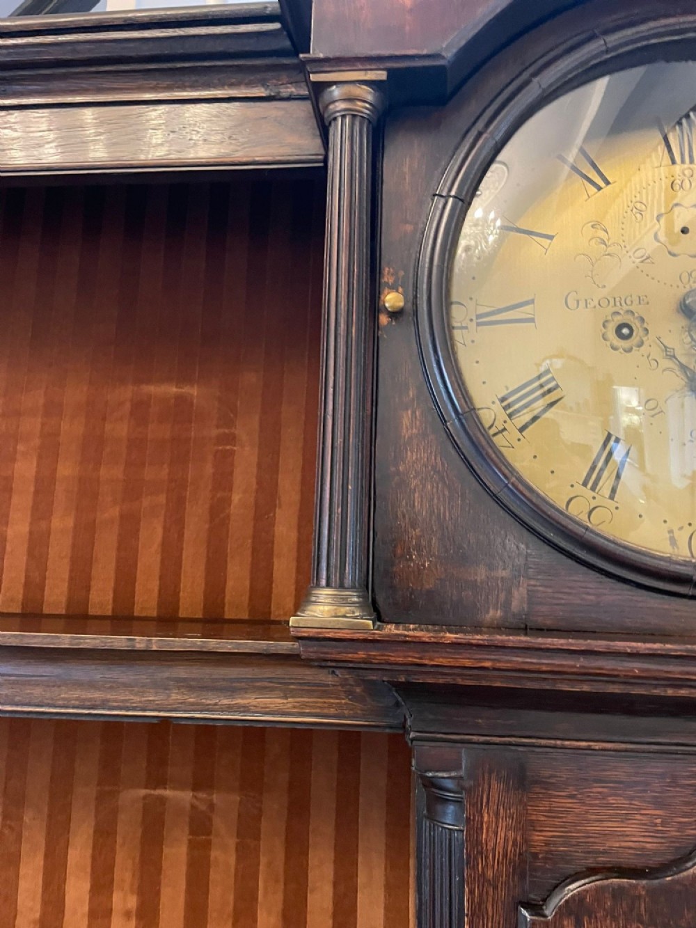 An eighteenth-century dark oak George III dresser featuring an upper shelf rack with an integrated central longcase clock over a base with three drawers and six arched panel cupboard doors. View XI