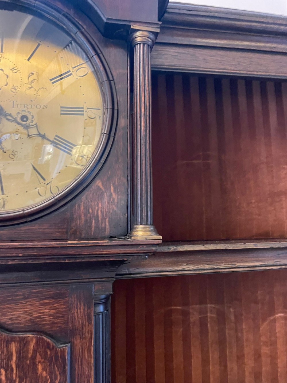 An eighteenth-century dark oak George III dresser featuring an upper shelf rack with an integrated central longcase clock over a base with three drawers and six arched panel cupboard doors. View XII