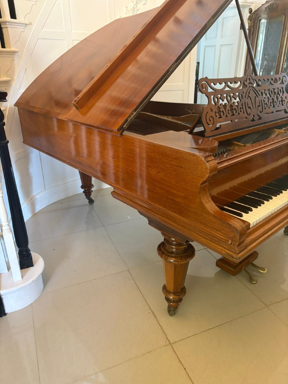 A late Victorian C. Bechstein Model V boudoir grand piano in rosewood, featuring a open top lid, carved fretwork music desk, turned legs, and brass castors. View IX