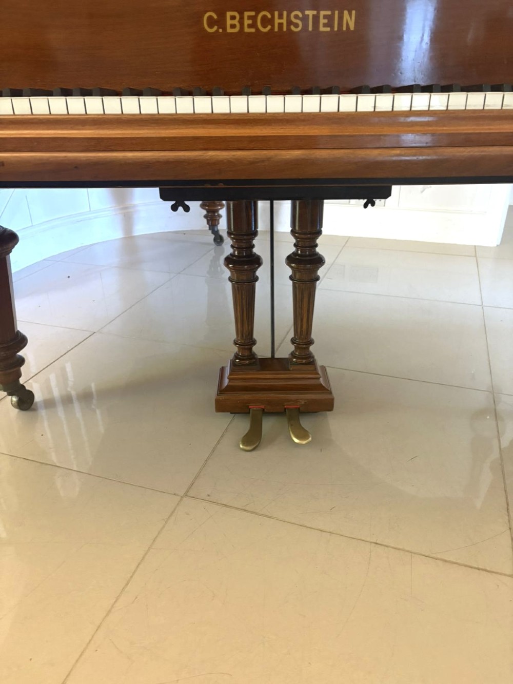 A late Victorian C. Bechstein Model V boudoir grand piano in rosewood, featuring a open top lid, carved fretwork music desk, turned legs, and brass castors. View XI
