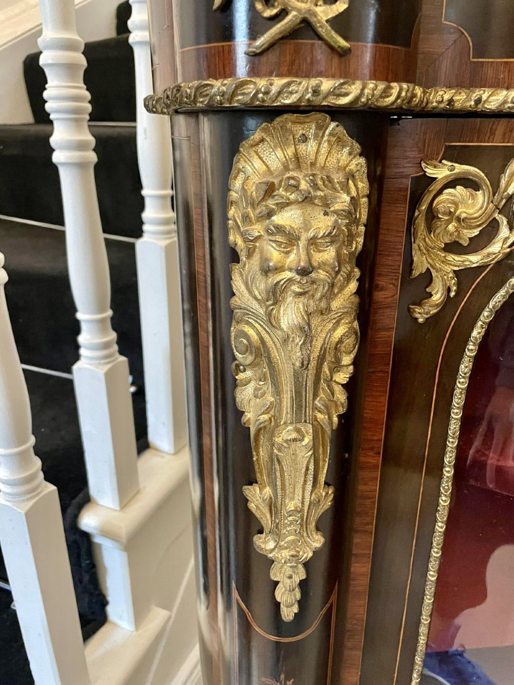 A dark wood Victorian serpentine credenza with floral marquetry inlay, gilt ormolu mounts, and two curved glass display doors. View XII