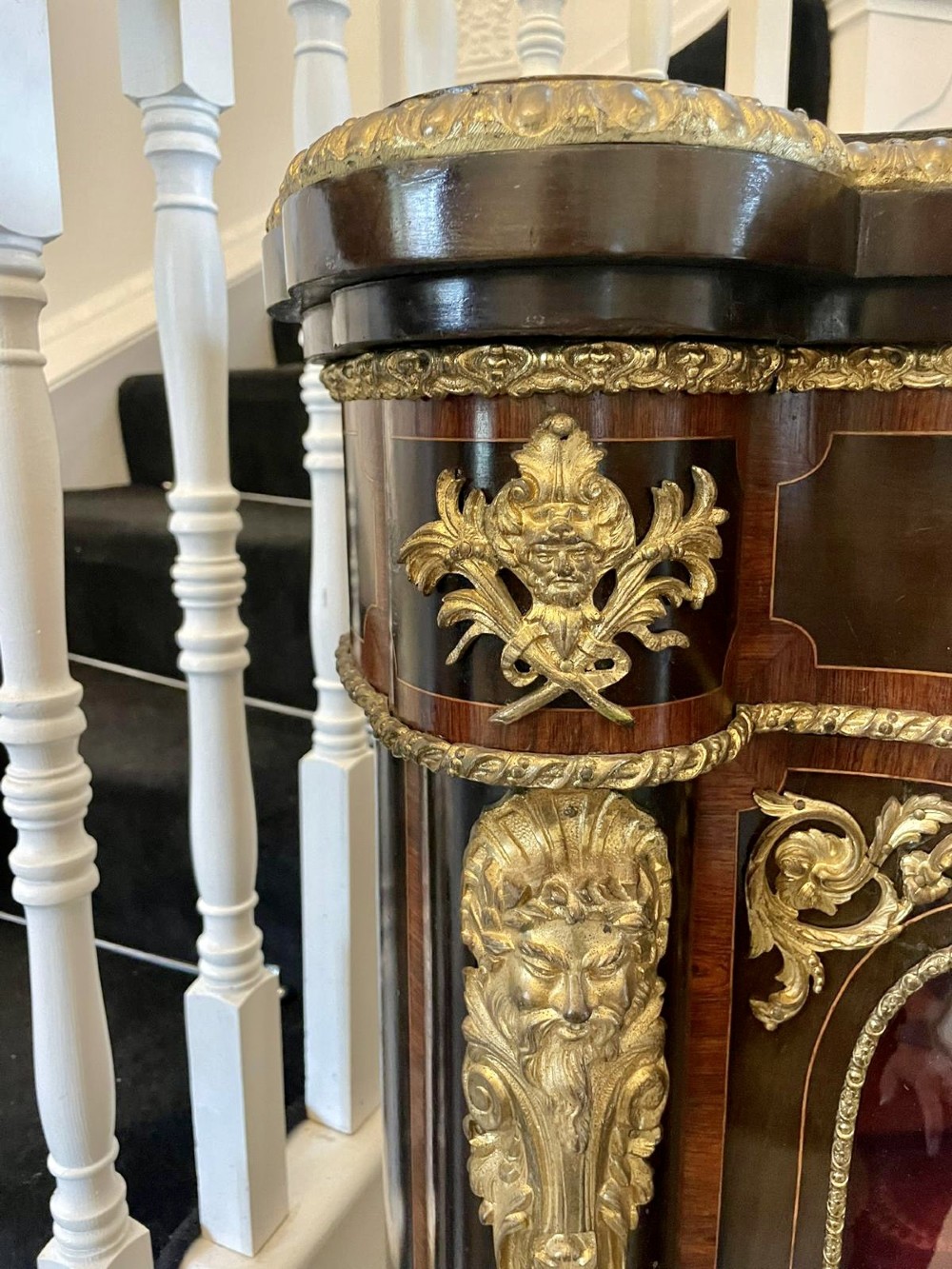 A dark wood Victorian serpentine credenza with floral marquetry inlay, gilt ormolu mounts, and two curved glass display doors. View XIV