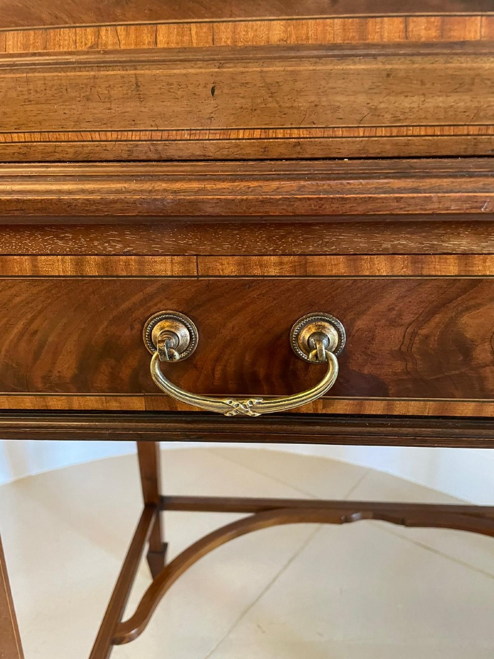 An Edwardian mahogany cylinder writing desk featuring satinwood inlay, brass gallery top rail, and tapered square legs. View VIII