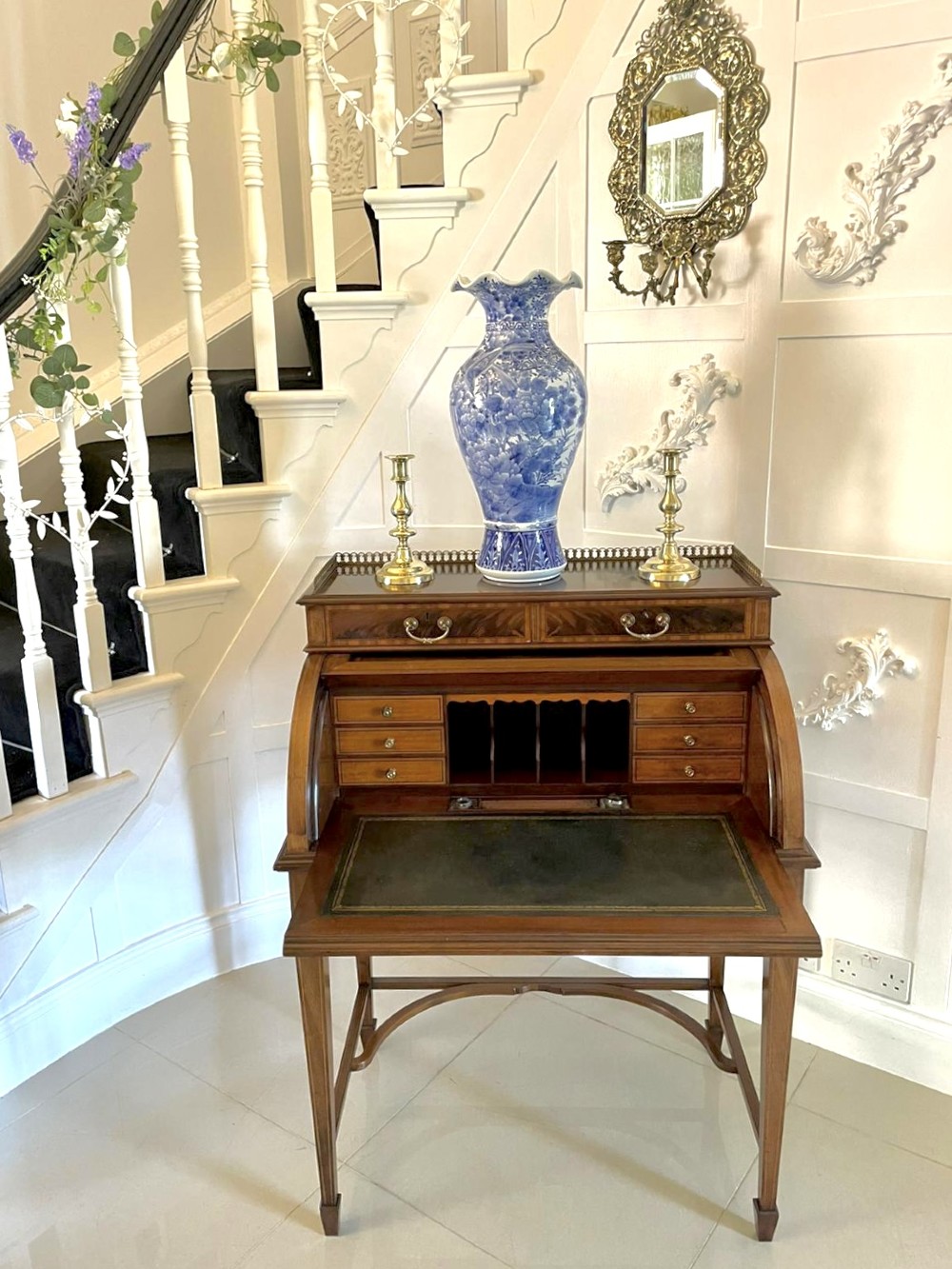 An Edwardian mahogany cylinder writing desk featuring satinwood inlay, brass gallery top rail, and tapered square legs. View IX