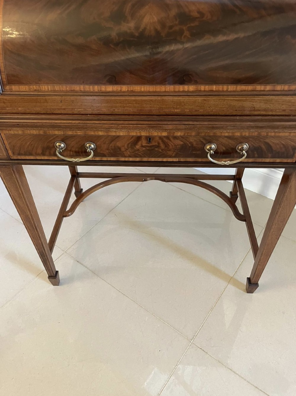 An Edwardian mahogany cylinder writing desk featuring satinwood inlay, brass gallery top rail, and tapered square legs. View XIV