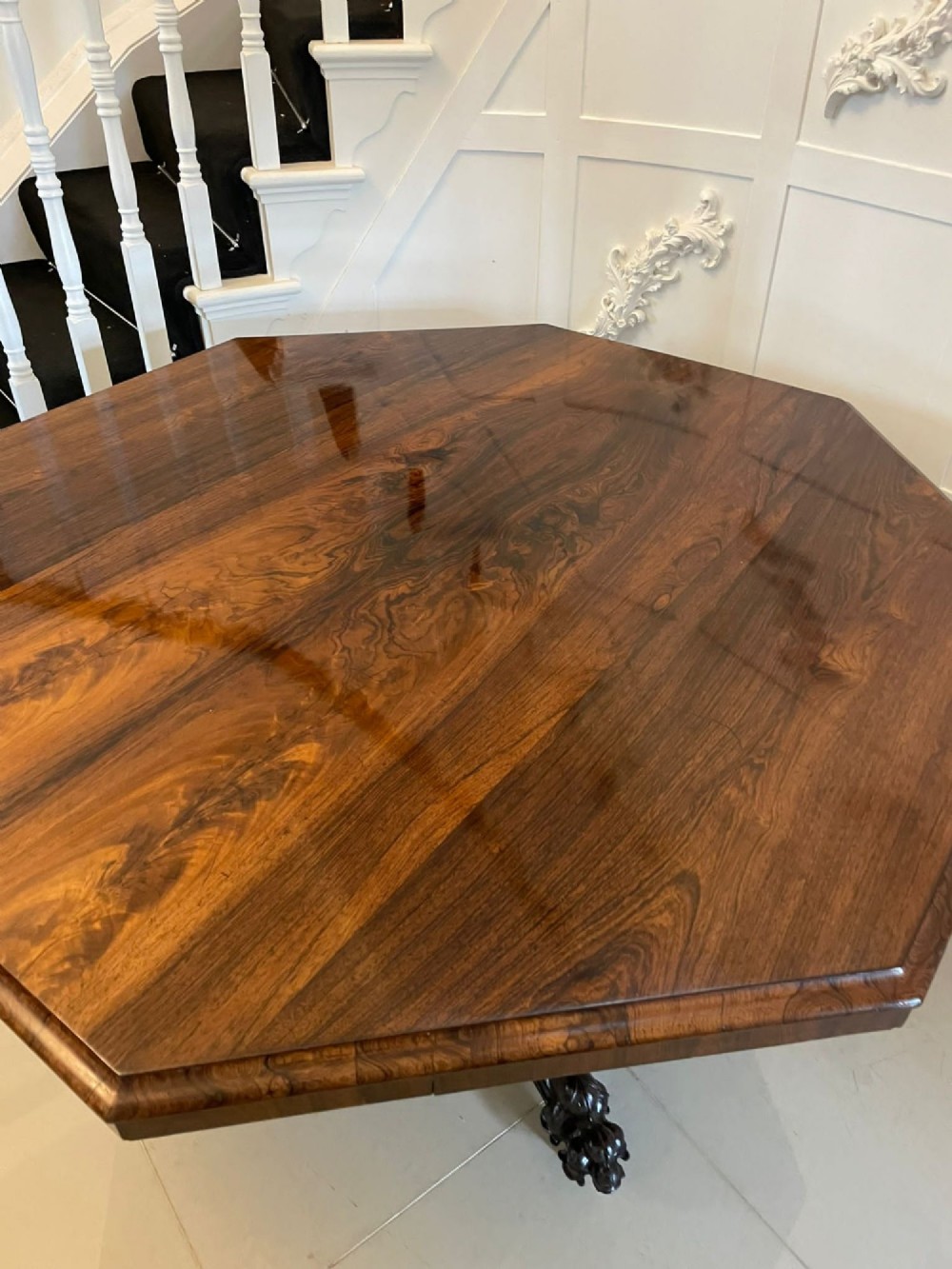 An Early Victorian octagonal rosewood tilt-top centre table with a highly figured grain surface resting on a carved pedestal base with scroll feet. View III