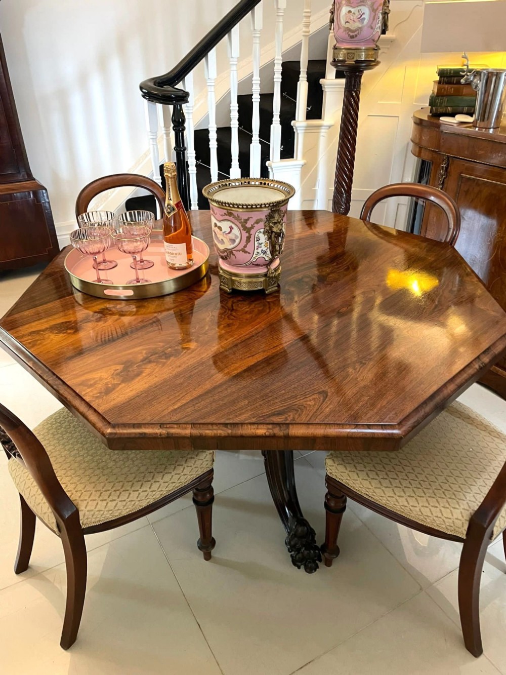 An Early Victorian octagonal rosewood tilt-top centre table with a highly figured grain surface resting on a carved pedestal base with scroll feet. View IX