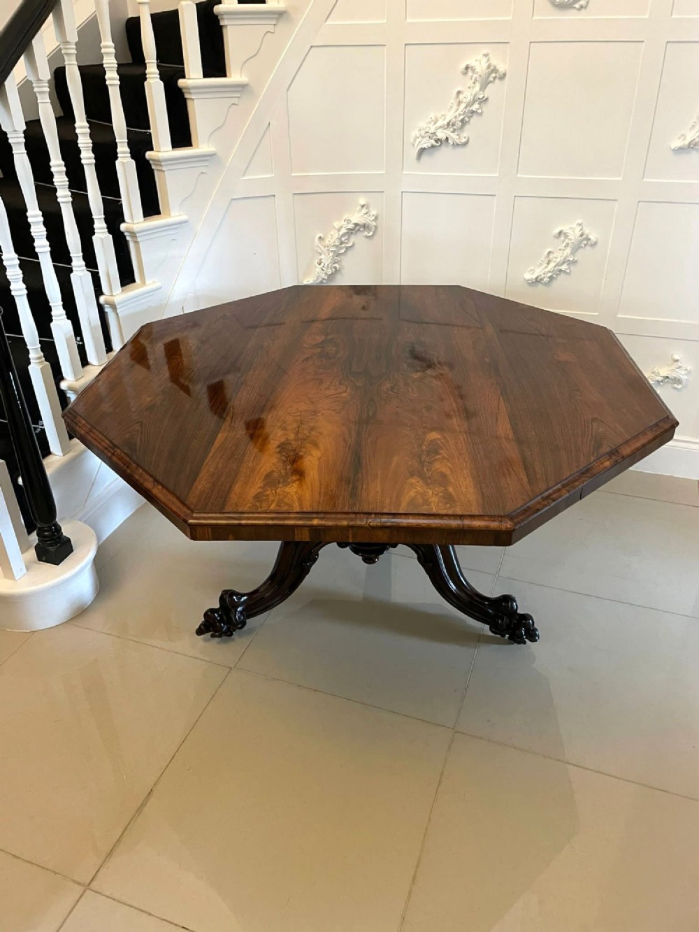 An Early Victorian octagonal rosewood tilt-top centre table with a highly figured grain surface resting on a carved pedestal base with scroll feet. View XIV