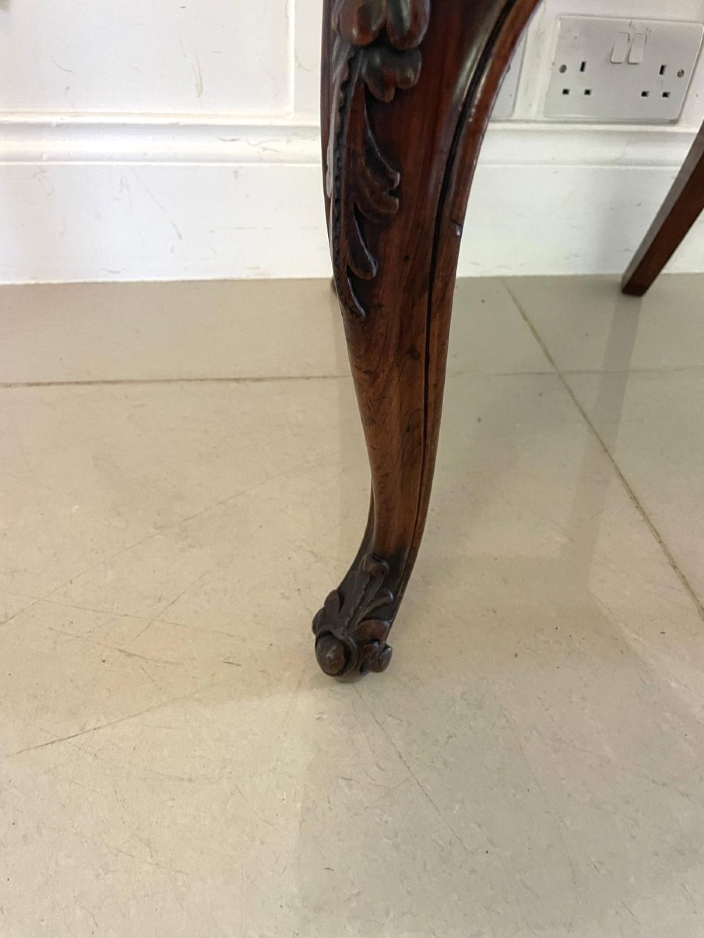 A set of six Victorian carved walnut dining chairs featuring rounded balloon backs, carved foliage detailing, cabriole front legs, and blue and white striped upholstered seats. View VI