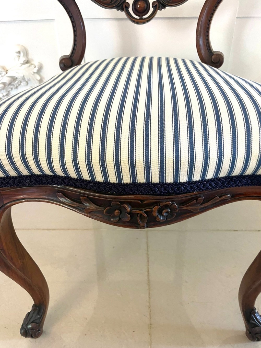 A set of six Victorian carved walnut dining chairs featuring rounded balloon backs, carved foliage detailing, cabriole front legs, and blue and white striped upholstered seats. View IX
