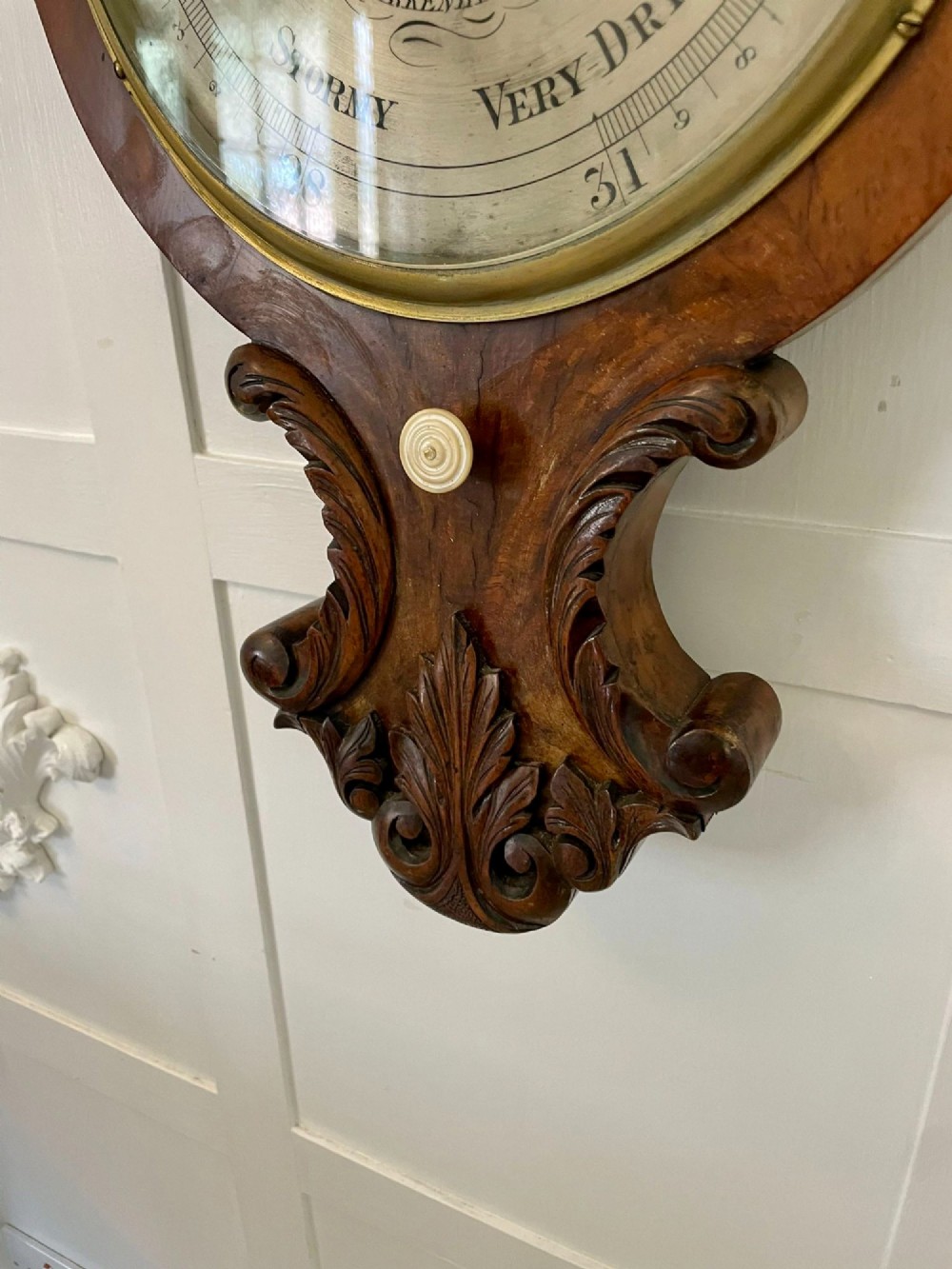 Victorian wall-mounted banjo barometer crafted from carved burr walnut featuring an upper glass thermometer gauge and a lower silvered dial in a brass frame. View VIII