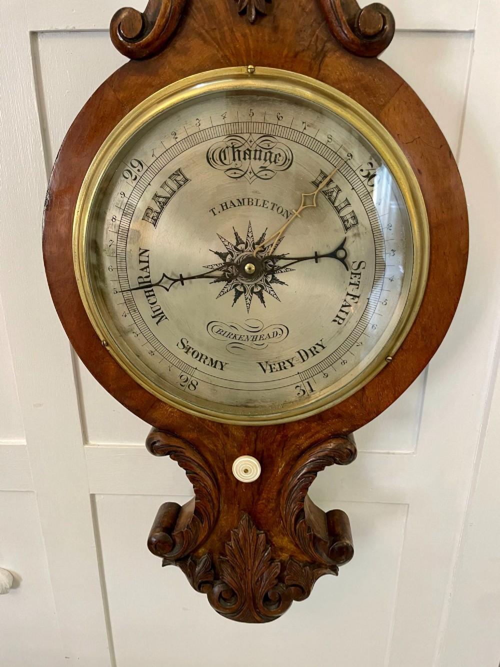 Victorian wall-mounted banjo barometer crafted from carved burr walnut featuring an upper glass thermometer gauge and a lower silvered dial in a brass frame. View XI