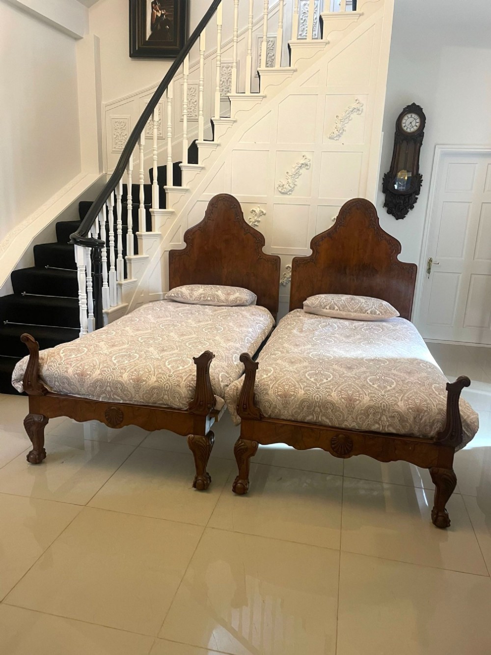 A pair of antique burr walnut single beds featuring high arched headboards, carved shell detailing on the aprons, and scroll-topped footposts. View XII