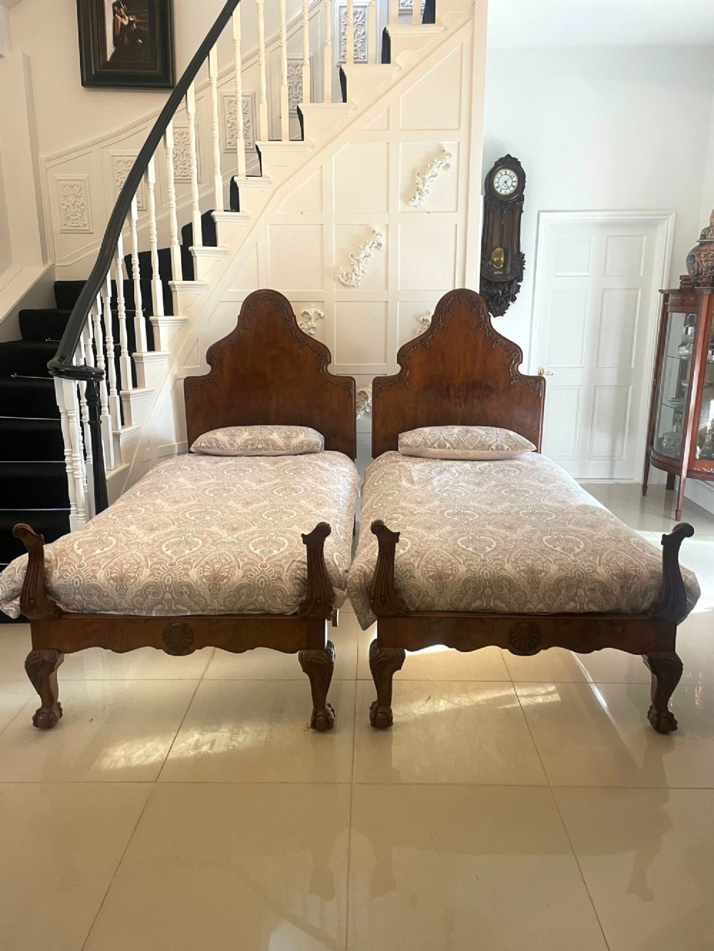 A pair of antique burr walnut single beds featuring high arched headboards, carved shell detailing on the aprons, and scroll-topped footposts. View XIII