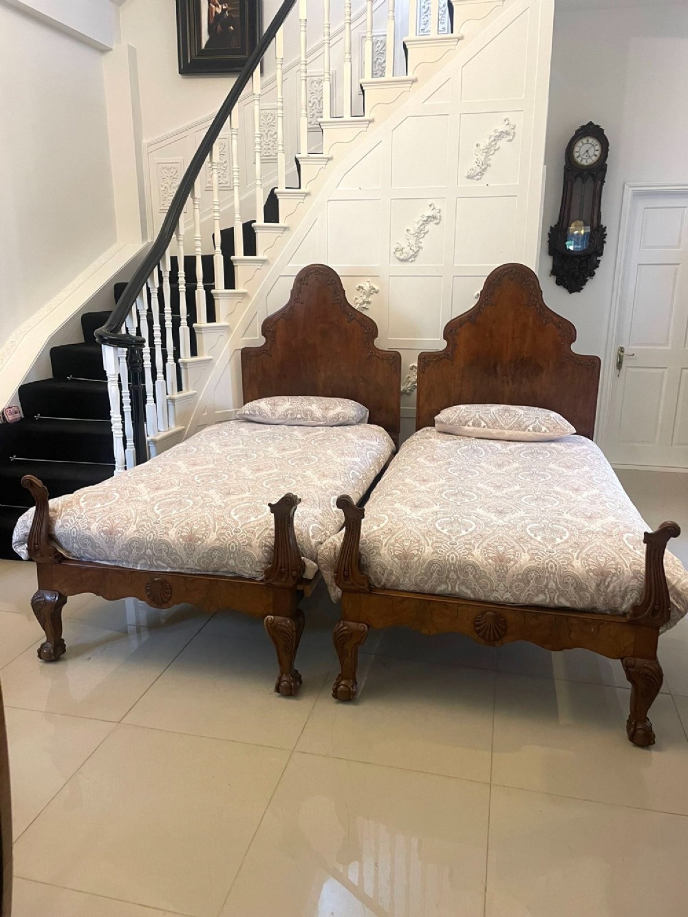 A pair of antique burr walnut single beds featuring high arched headboards, carved shell detailing on the aprons, and scroll-topped footposts. View XIV