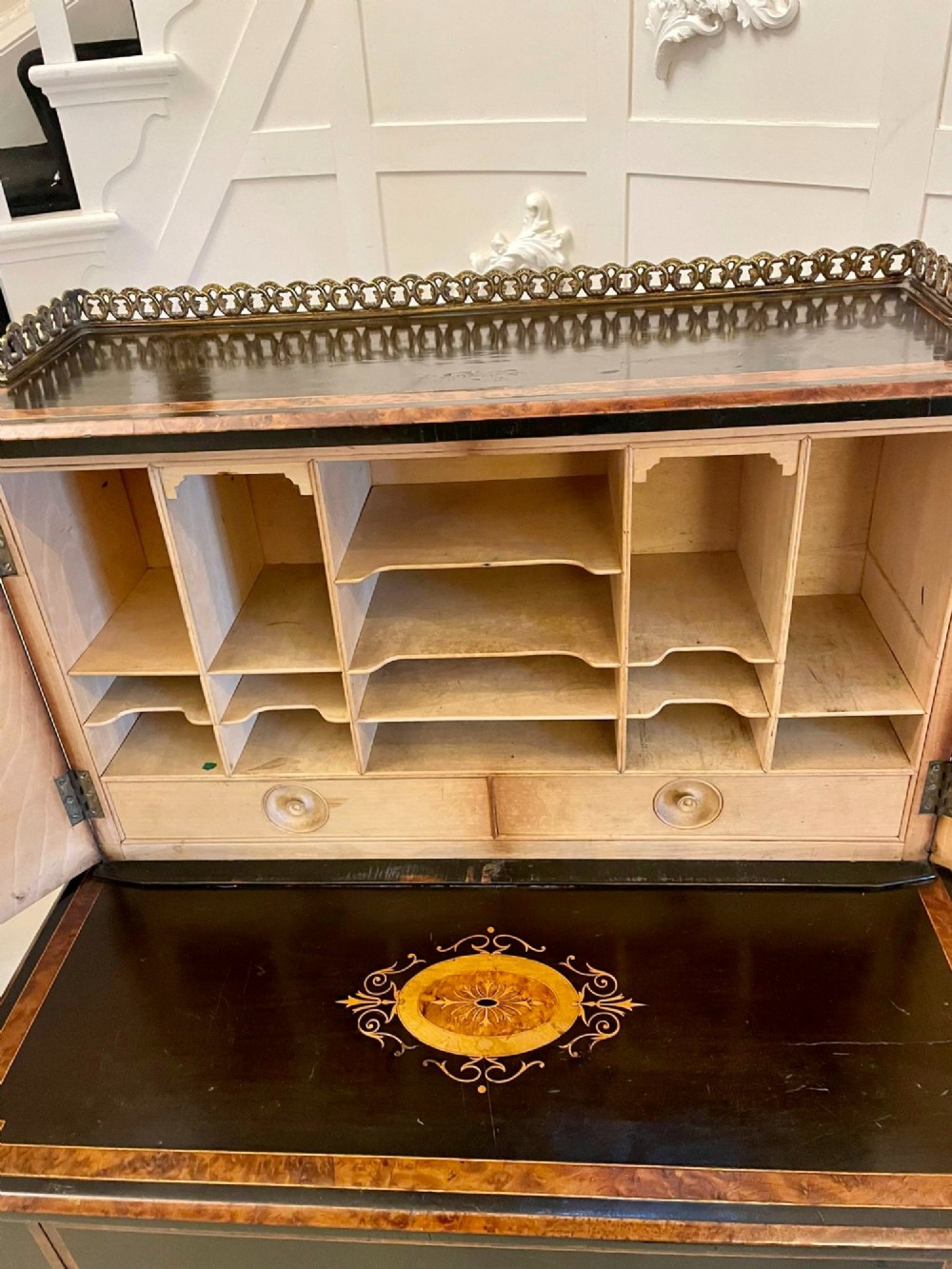 A Victorian ebonised writing desk featuring burr walnut inlaid panels, central oval marquetry medallions, and a pierced brass gallery along the top. View X