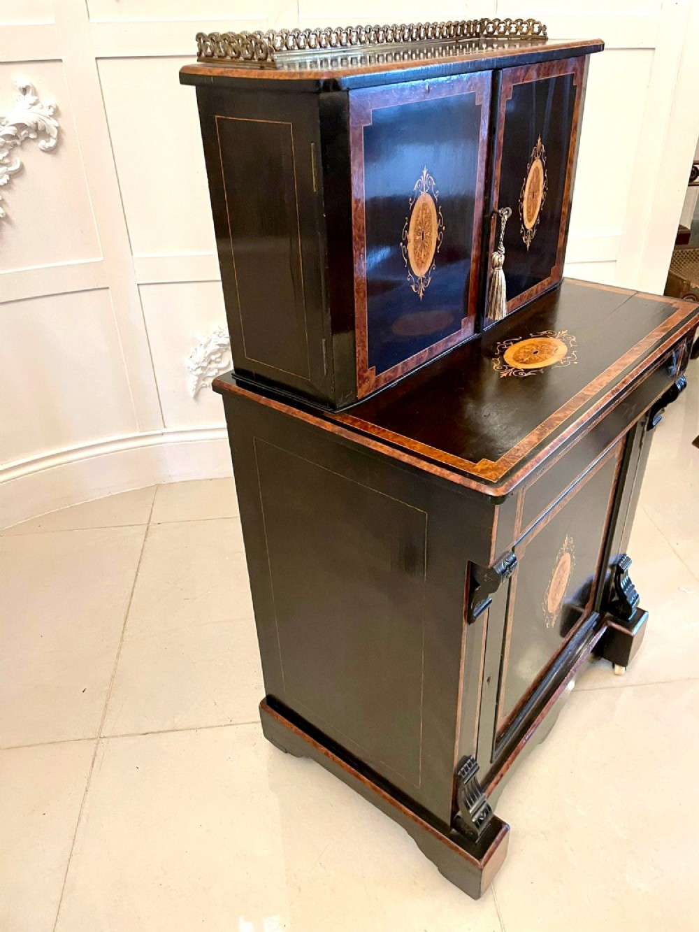A Victorian ebonised writing desk featuring burr walnut inlaid panels, central oval marquetry medallions, and a pierced brass gallery along the top. View XV