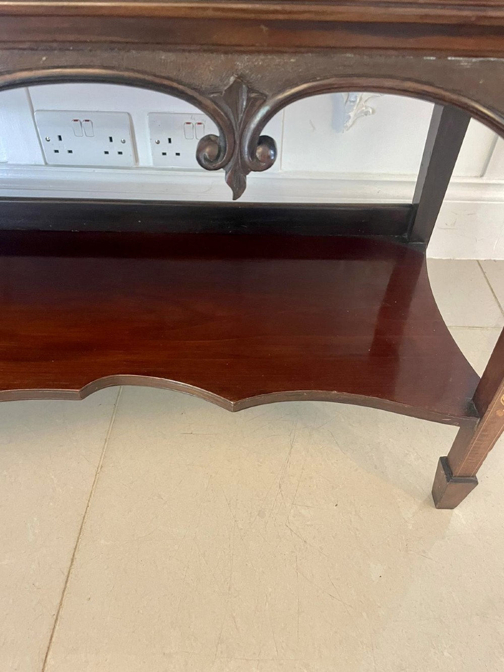 A large Victorian mahogany display cabinet featuring a carved pediment top, central bevelled mirror back, floral satinwood marquetry panel, glazed doors, and a bottom shelf. View XII