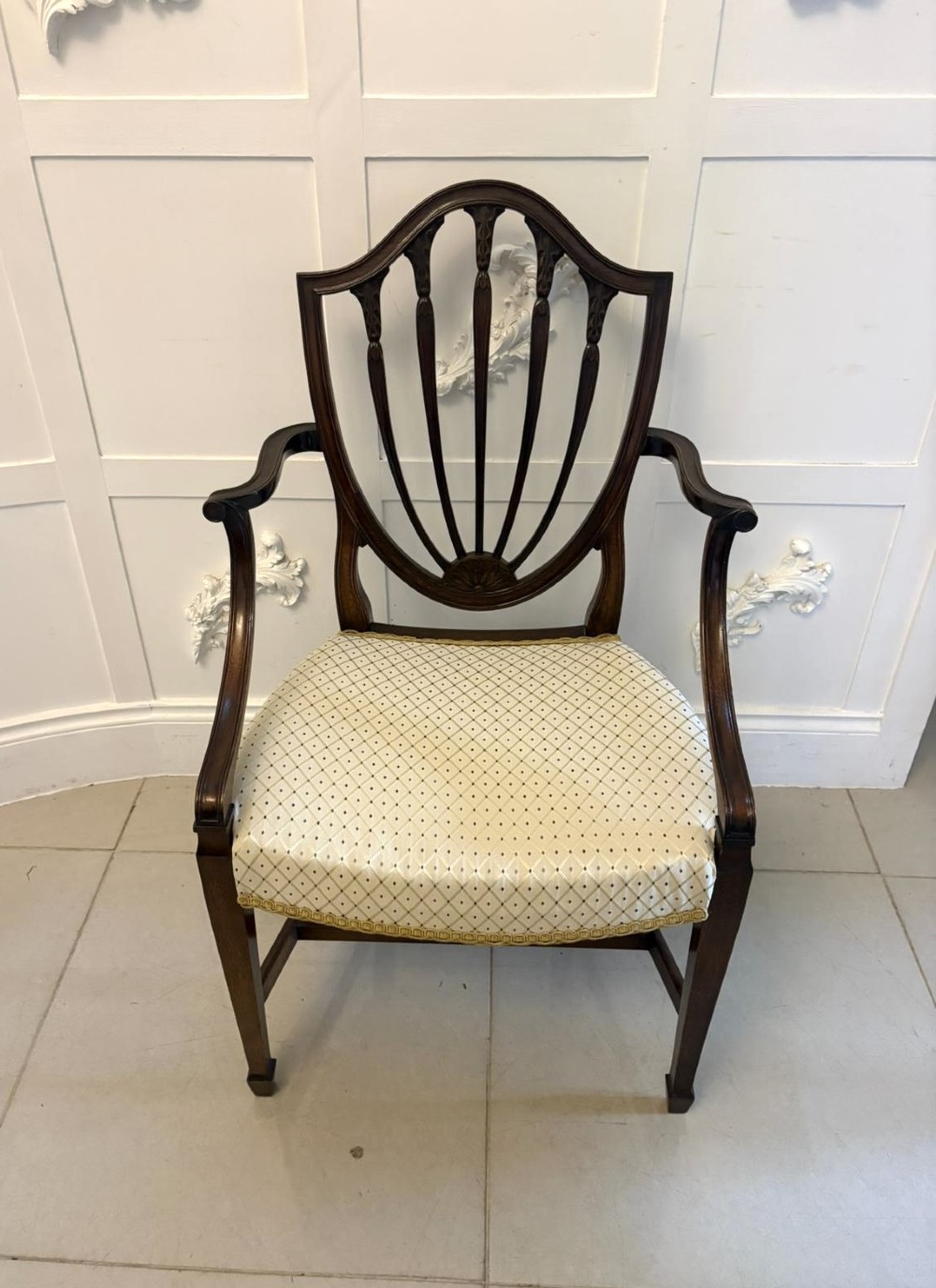 A set of ten antique Edwardian mahogany dining chairs featuring carved shield-shaped backrests and light cream upholstered seats. View VIII