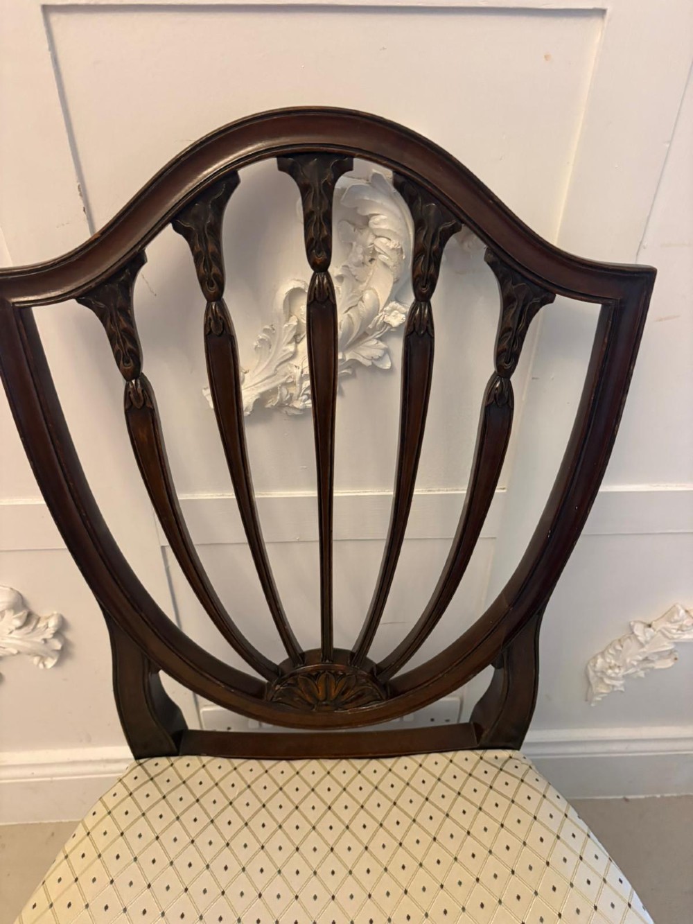 A set of ten antique Edwardian mahogany dining chairs featuring carved shield-shaped backrests and light cream upholstered seats. View XIV