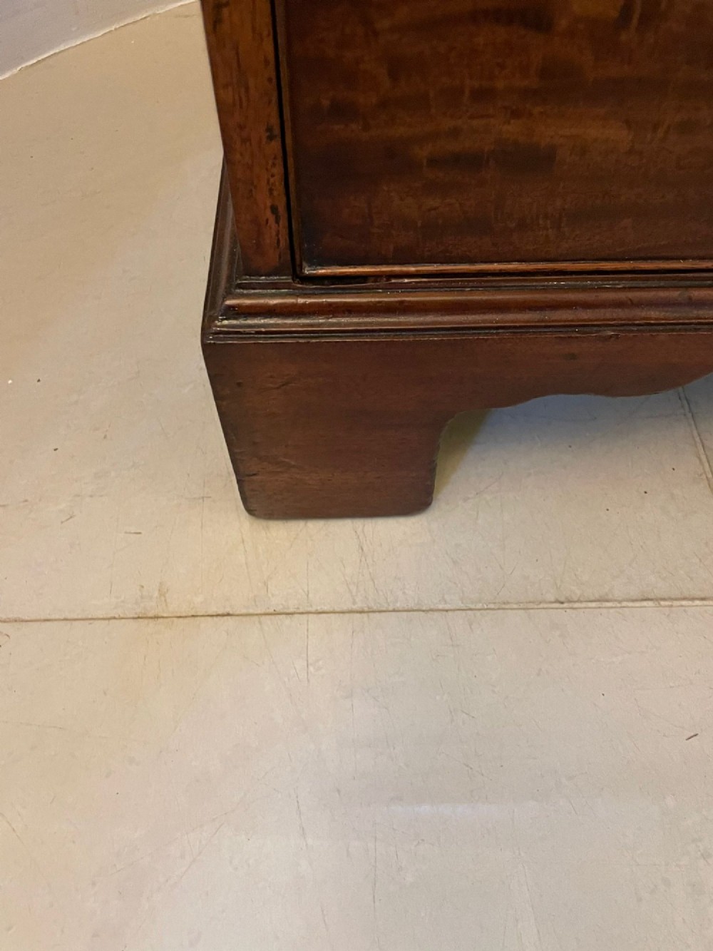 A George III mahogany chest of drawers featuring a two-over-three drawer configuration with brass swan-neck handles on bracket feet. View VII