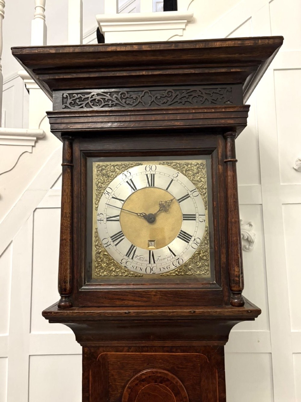 A George III oak and burr oak longcase clock featuring a square brass dial, fretwork hood frieze, and a long waist door. View XII